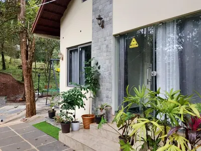 a house with plants in front of a window at Skygarden Resort Vythiri in Vythiri