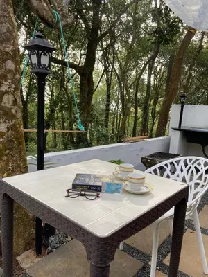 a table with glasses and a book on it at Skygarden Resort Vythiri in Vythiri