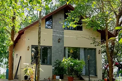 a house with trees in front of it at Skygarden Resort Vythiri in Vythiri