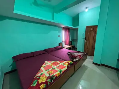 a bedroom with a bed with purple sheets at Park view homestays in Vālpārai