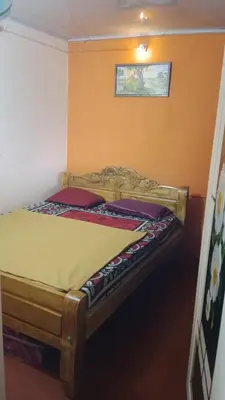 a wooden bed in a room with at Danny's Homestay Coorg in Madikeri