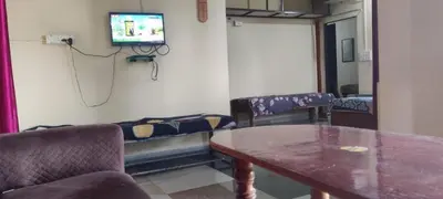 a room with a table and a tv on a wall at Danny's Homestay Coorg in Madikeri