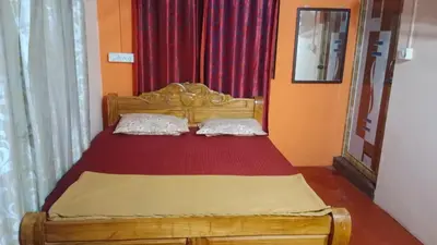 a wooden bed with two pillows in a bedroom at Danny's Homestay Coorg in Madikeri