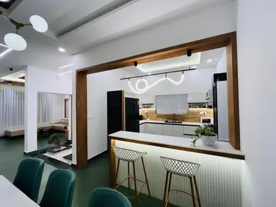 a kitchen with a bar and some blue chairs at Mistora Stays 2BHK Private villa in Kalpetta