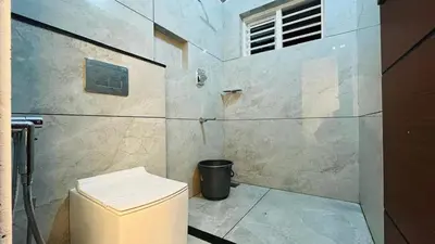 a bathroom with a toilet and a glass wall at Mistora Stays 2BHK Private villa in Kalpetta