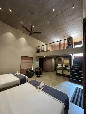 a hotel room with two beds and a staircase at WyldWater Retreat in Vythiri