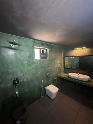 a bathroom with a toilet and a sink at WyldWater Retreat in Vythiri