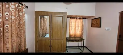 a room with a wooden door and a table at Deepam Homestay in Coimbatore