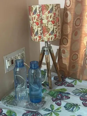 a lamp and two glass bottles on a table at Deepam Homestay in Coimbatore