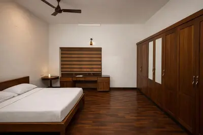 a bedroom with a bed and a dresser and a window at Heritage Home in Ernakulam North Paravur in Ernakulam