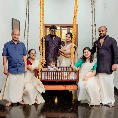 a family posing for a picture on a swing at Heritage Home in Ernakulam North Paravur in Ernakulam