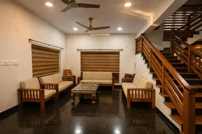 a living room with couches and a stair case at Heritage Home in Ernakulam North Paravur in Ernakulam
