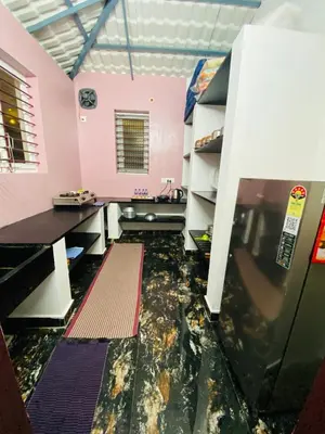 an empty room with a refrigerator and a counter at Thulir Farm Stay Near Isha Yoga Adiyogi in Coimbatore