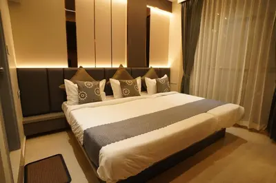 a bedroom with a large bed with pillows at The Grand Sarayu in Mysore
