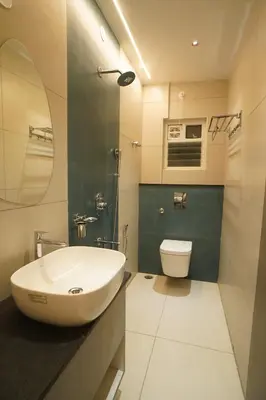 a bathroom with a sink and a toilet and a mirror at The Grand Sarayu in Mysore