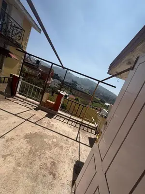 a building with a gate with a view of a field at KINGS Home Stay in Ooty