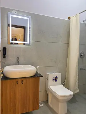 a bathroom with a sink and a toilet and a mirror at Sunset Villa Dusk looks better from here in Mysore