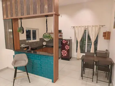 a kitchen and dining room with a table and chairs at Sunset Villa Dusk looks better from here in Mysore