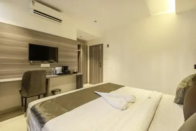 a hotel room with a bed with a towel on it at Hotel Hycon in Kozhikode