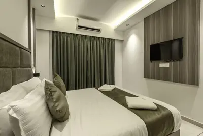 a hotel room with a bed and a television at Hotel Hycon in Kozhikode