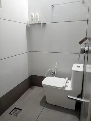 a white bathroom with a toilet and a sink at Izzath Villa in Kottakkal