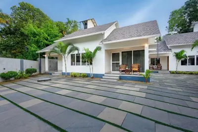 a house with a stone patio in front of it at New Abrigo Resorts in Perintalmanna
