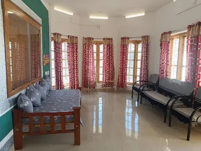 a room with benches and windows with red curtains at SoNish Homestay Marayur - 3 bedroom for 25-30 people - Booking will be confirmed only after advance payment in Marayoor