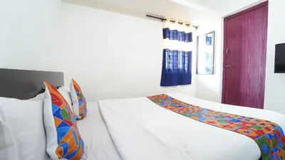 a bedroom with a white bed with a colorful blanket at Thai Residency in Coimbatore