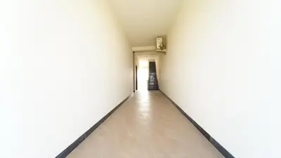 an empty corridor with white walls and a long hallway at Thai Residency in Coimbatore