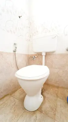 a bathroom with a white toilet in a room at Thai Residency in Coimbatore