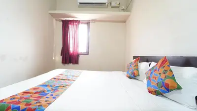 a bedroom with a large white bed with colorful pillows at Thai Residency in Coimbatore