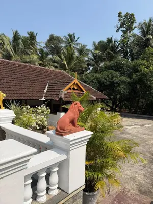 a statue of a horse sitting on the ledge of a building at Homestay in Alappura 3 Cottage Farmstay by Homeyhuts in Tattamangalam