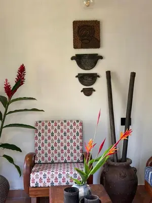 a living room with a chair and plants on the wall at Homestay in Alappura 3 Cottage Farmstay by Homeyhuts in Tattamangalam