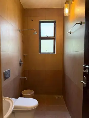 a bathroom with a toilet and a sink and a window at Homestay in Alappura 3 Cottage Farmstay by Homeyhuts in Tattamangalam