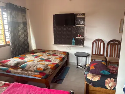 a room with a bed and two chairs in it at 4 Beds 6 People stay Calm, Comfortable Place in Mysore
