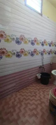 a bathroom with a toilet and flowers on the wall at Yakuhomestay in Vālpārai