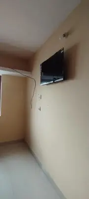 a room with a tv on the wall at Yakuhomestay in Vālpārai