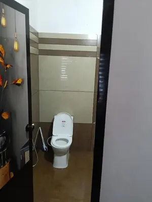 a bathroom with a white toilet in a stall at Anjali Holiday Home in Tindummal