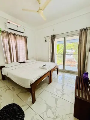 a bedroom with a bed and a large window at MIRACLE INN Rajagiri in Cochin