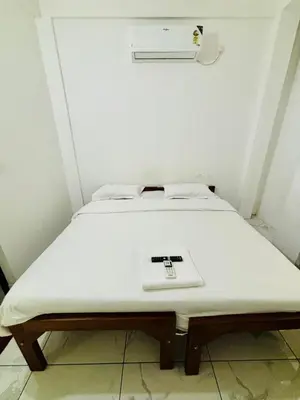 a white bed with a scale on top of it at MIRACLE INN Rajagiri in Cochin