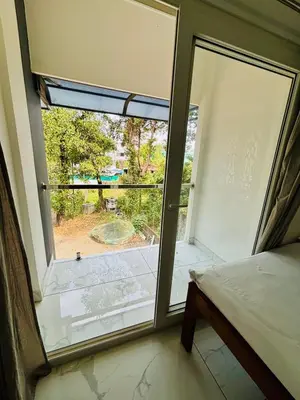 a bedroom with a large window with a view of a yard at MIRACLE INN Rajagiri in Cochin