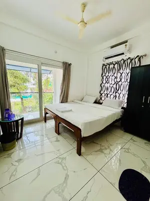 a bedroom with a bed and a large window at MIRACLE INN Rajagiri in Cochin