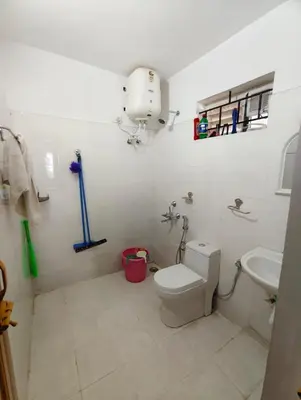 a white bathroom with a toilet and a sink at MISTY cottage in Ooty