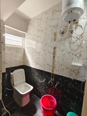 a small bathroom with a toilet and a sink at MISTY cottage in Ooty