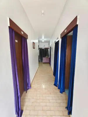 a hallway with purple drapes and a row of doors at MISTY cottage in Ooty