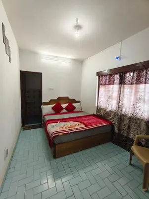 a bedroom with a bed with red pillows on it at MISTY cottage in Ooty