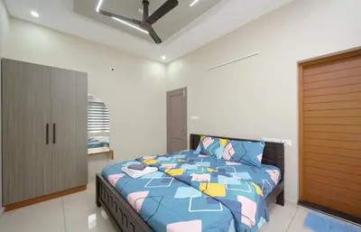 a bedroom with a bed and a ceiling fan at 4-Bedroom Villa near CIAL Airport 25 Min Drive ! in Alwaye