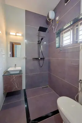 a bathroom with a shower with a sink and a toilet at 4-Bedroom Villa near CIAL Airport 25 Min Drive ! in Alwaye