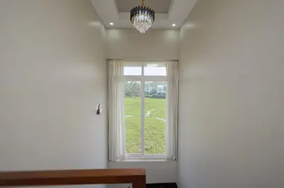 a window in a room with a table and a chandelier at 4-Bedroom Villa near CIAL Airport 25 Min Drive ! in Alwaye