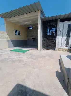 a building with a garage with a gate at Affordable home stay in Chāmrājnagar